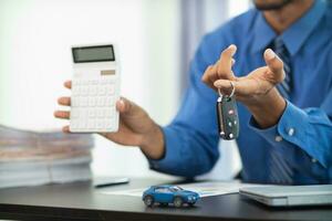 The car showroom car dealer handed over the keys to the customer after the purchase contract was finalized. The concept of buying and selling car with a trusted dealer for peace of mind. photo