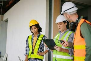 Engineers are discussing data working and laptop or tablet with architectural project at new construction site on big project. photo