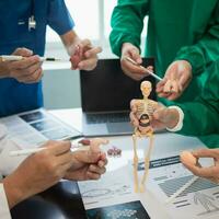 Medical team meeting with surgical surgeon in white coats and surgical team discussing patient condition documenting successful medical health treatment. concept of working with medical team photo