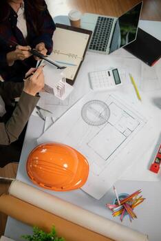 Architects and engineers discuss how to design  housing estate to ensure construction is up to standard and completed on time. team of engineers and architects discuss building design and structure. photo