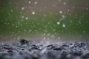 Background of many rain drops falling on the ground due to heavy rain during the rain season causing water splashing from a large number of plots on a blurred background of dark spray. photo