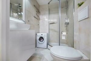 toilet and detail of a corner shower cabin with wall mount shower attachment photo