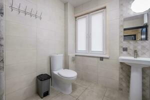 toilet and detail of a corner shower cabin with wall mount shower attachment photo