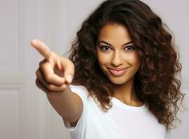 Young girl looking at camera while pointing her finger photo