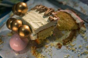 Slice of Delicious birthday cake on plate on white table on light background with blurred background photo