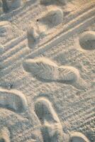 The background of a sandy beach with footprints. Sand beach background photo