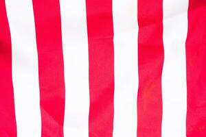 horizontally-oriented flag background with red and white stripes filling the majority of the frame photo