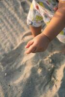 cerca arriba de niño manos excavación en el playa arena foto