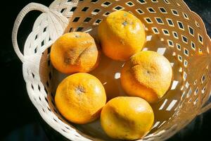 Fresh and ripe sunkist oranges fruits. Served in rattan basket. photo