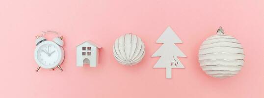 Simply minimal composition winter objects ornament fir tree ball alarm clock isolated on pink pastel trendy background photo