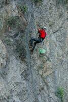 Climber placing safety nets to avoid falling rocks photo