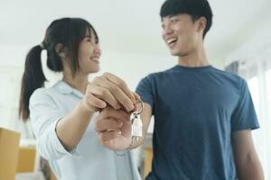 Happy young couple buying a new house receiving the keys. photo