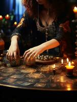 un fortuna cajero lee tarot tarjetas en el mesa son velas y adivinación objetos y chispas. el concepto de Adivinación, astrología y esoterismo foto