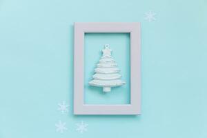 Simply minimal composition winter objects ornament fir tree in pink frame isolated on blue pastel trendy background photo