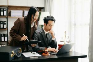 Asian business team and lawyers discussing contract papers sitting at the table. Concepts of law, advice, legal services. at modern office photo