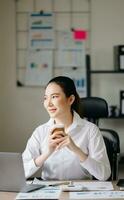 Asian businesswoman working in the office with working notepad, tablet and laptop documents photo