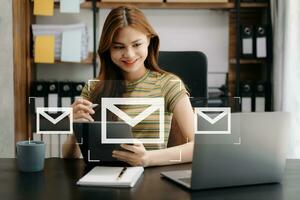 Woman hands using Laptop, tablet typing on keyboard and surfing the internet with email icon, email marketing concept, send e-mail or newsletter, online working internet network technology. photo