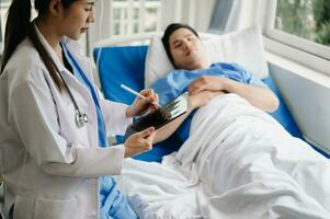 Doctor discussing treatment with male patient talking and laughing sitting on examination bed in clinic or hospital photo