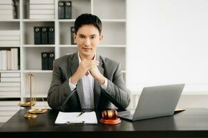 justice and law concept .Asian Male judge in a courtroom on table and Counselor working in office. photo