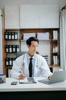 médico tecnología concepto. asiático médico trabajando con móvil teléfono y estetoscopio en moderno oficina foto