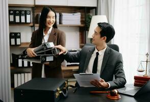 Asian business team and lawyers discussing contract papers sitting at the table. Concepts of law, advice, legal services. at modern office photo