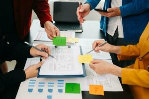 UX developer and ui designer brainstorming about mobile app interface wireframe design with customer breif and color code at office. photo