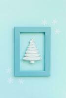 Simply minimal composition winter object ornament fir tree in blue frame isolated on blue pastel trendy background photo