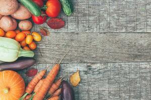 Assortment different fresh organic vegetables on country style wooden background. Healthy food vegan vegetarian dieting concept. Local garden produce clean food. Frame top view flat lay copy space. photo