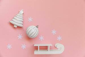 simplemente mínimo composición invierno objetos ornamento pelota abeto árbol trineo aislado en rosado pastel de moda antecedentes foto