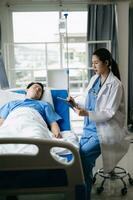 Doctor discussing treatment with male patient talking and laughing sitting on examination bed in clinic or hospital photo