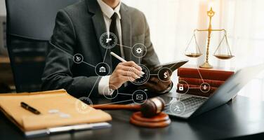 justice and law concept.Male judge in a courtroom  the gavel, working with smart phone and laptop and digital tablet computer on wood table photo