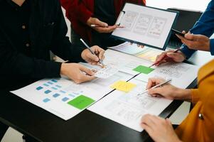 Close up view of UI developer team brainstorming on their project with laptop, smartphone and digital tablet. Creative digital development agency. photo