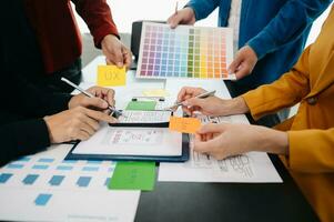 UX developer and ui designer brainstorming about mobile app interface wireframe design with customer breif and color code at office. photo