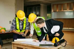 Engineers are discussing data working and laptop or tablet with architectural project at new construction site on big project. interior photo