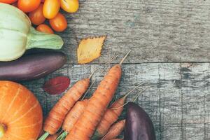 Assortment different fresh organic vegetables on country style wooden background. Healthy food vegan vegetarian dieting concept. Local garden produce clean food. Frame top view flat lay copy space. photo