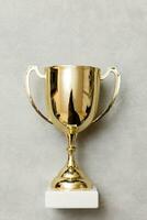 Simply flat lay design winner or champion gold trophy cup on concrete stone grey background. Victory first place of competition. Winning or success concept. Top view copy space. photo