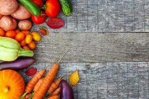 Assortment different fresh organic vegetables on country style wooden background. Healthy food vegan vegetarian dieting concept. Local garden produce clean food. Frame top view flat lay copy space. photo