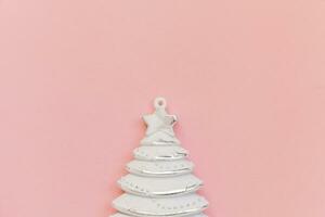 Simply minimal composition winter objects ornament fir tree isolated on pink pastel trendy background photo