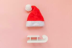 Simply minimal composition Christmas Santa Claus hat sled isolated on pink pastel colorful trendy background photo