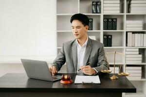 justice and law concept .Asian Male judge in a courtroom on table and Counselor working in office. photo
