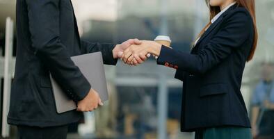 Business people shaking hands during a meeting. Two happy mature businessmen and woman photo