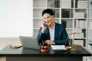 Attractive young lawyer in office Business man and lawyers discussing contract papers laptop and tablet with brass scale on  desk in modern office. Law, legal services, advice, photo