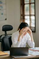 Asian business woman is stressed, bored, and overthinking from working on a tablet at the  office. photo