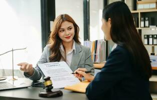 Two lawyers are discussing about contract paper, law matters determination, pointing.law and hammer on the table photo