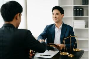 Asian business team and lawyers discussing contract papers sitting at the table. Concepts of law, advice, legal services. at office photo