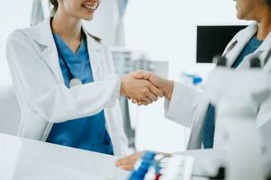 Doctor, handshake and partnership in healthcare, medicine or trust for collaboration, unity or support.Team of medical experts shaking hands in teamwork for or success in clinic or hospital photo
