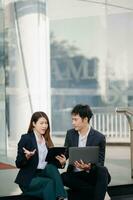 Businesswoman and man walking and talking on street in city Outside Office with ,young couple discussing and drinking coffee together, partners, teamwork photo