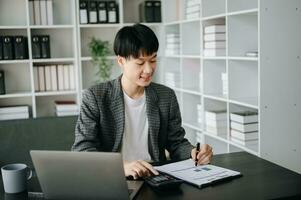 una mujer independiente está trabajando en su trabajo en una tableta de computadora y una computadora portátil haciendo un informe de análisis contable de datos de inversión inmobiliaria, financieros en la oficina foto