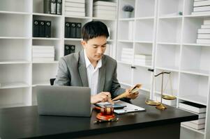 justice and law concept.businessman or lawyer or accountant working on accounts using a smart phone laptop digital tablet calculator and documents in modern office photo