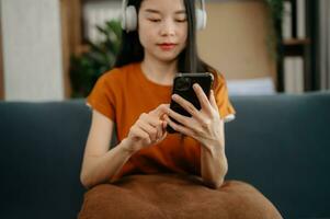 Woman using smart phone for mobile payments online shopping, omni channel, sitting on table, virtual icons graphics interface screen photo